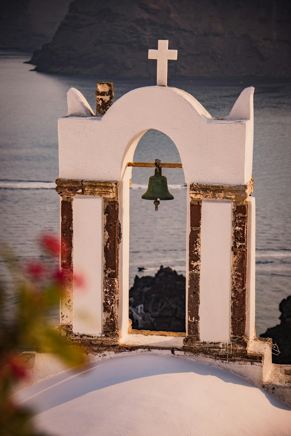 white concrete cross near body of water during daytime