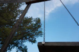 A backyard swing set freshly assembled with a clear blue sky overhead.