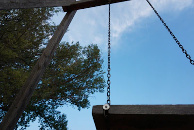 A backyard swing set freshly assembled with a clear blue sky overhead.