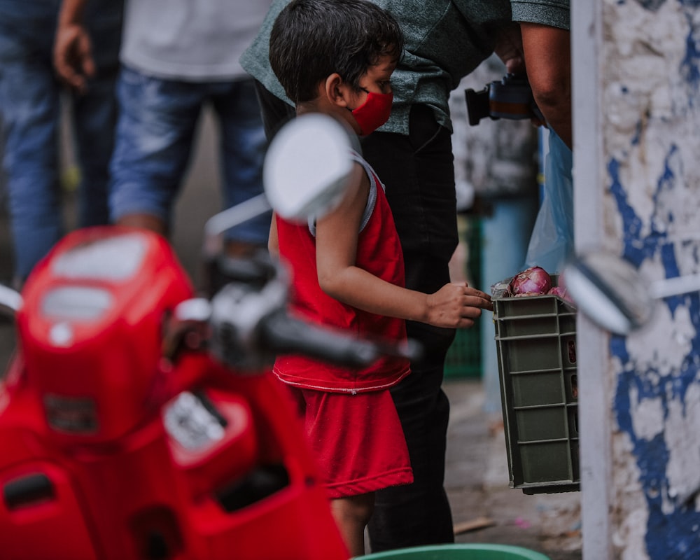 Hombre con camiseta roja y pantalones cortos rojos sosteniendo un marco de metal gris