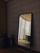 Custom large mirror with sleek edges reflecting a stylish living room.