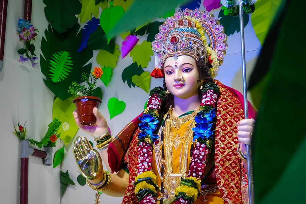 a statue of a hindu god holding a pot