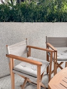 Close-up of waterproof cushioned patio chairs beside a round rattan dining table.