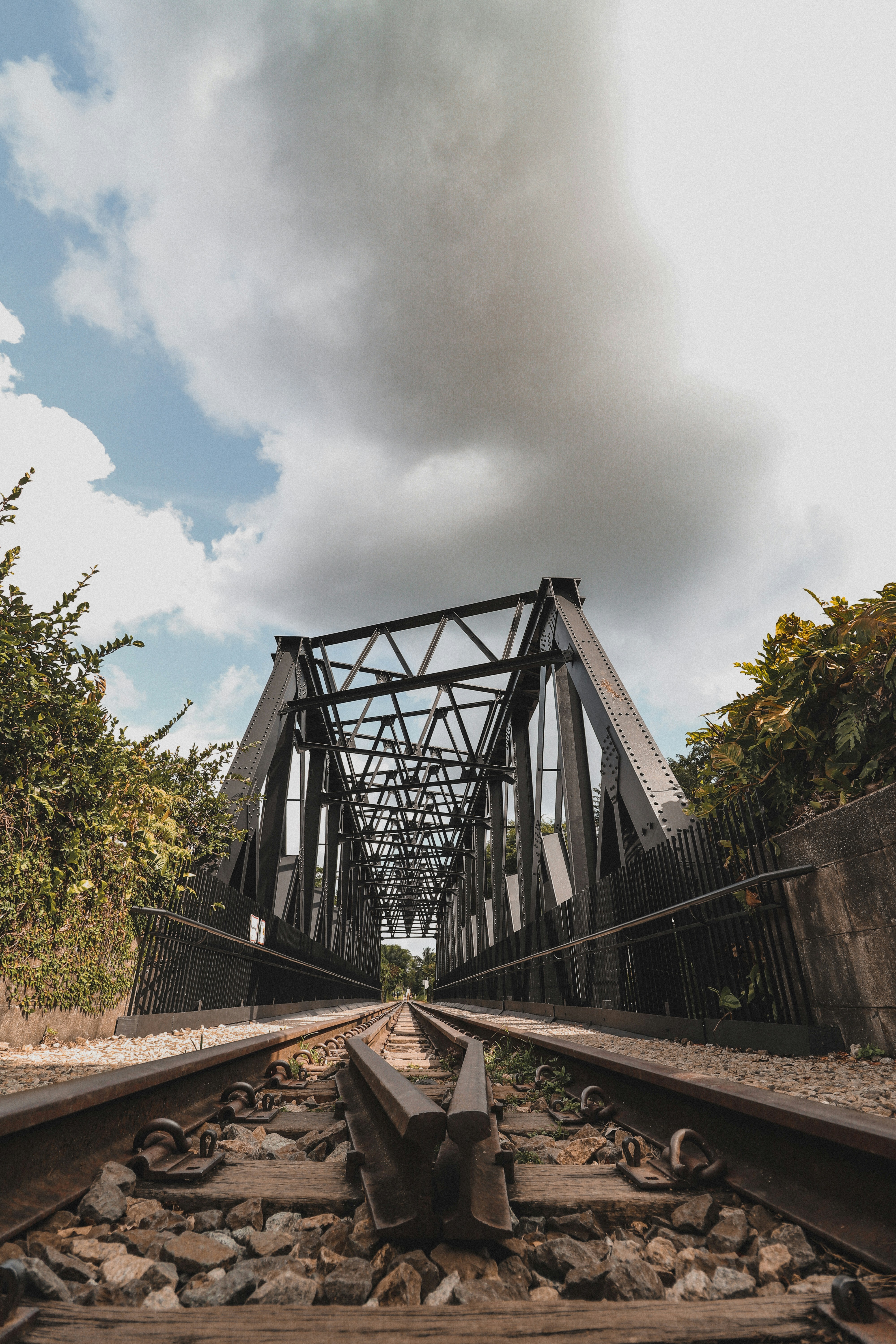 gray metal bridge under white clouds during daytime