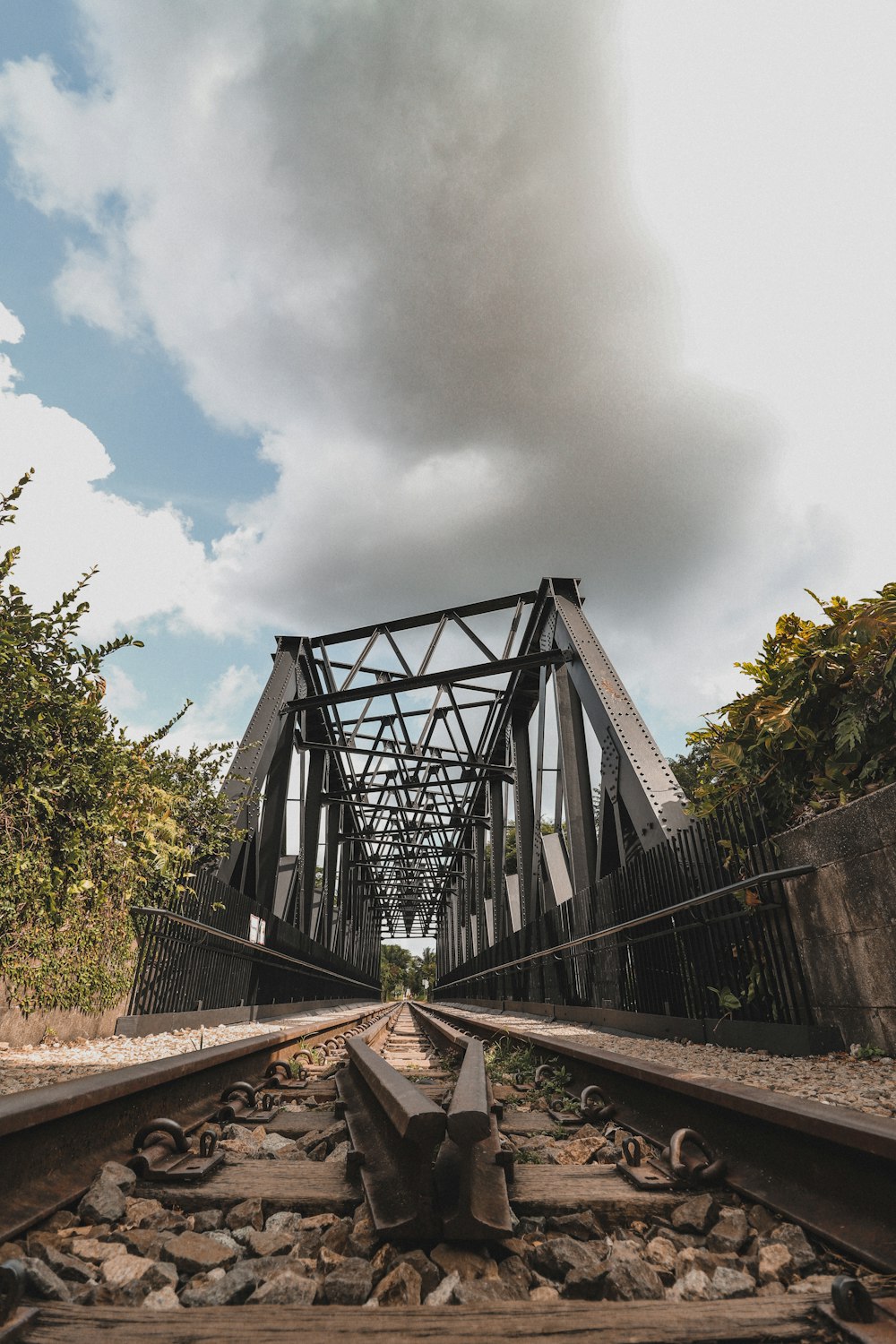 ponte de metal cinza sob nuvens brancas durante o dia