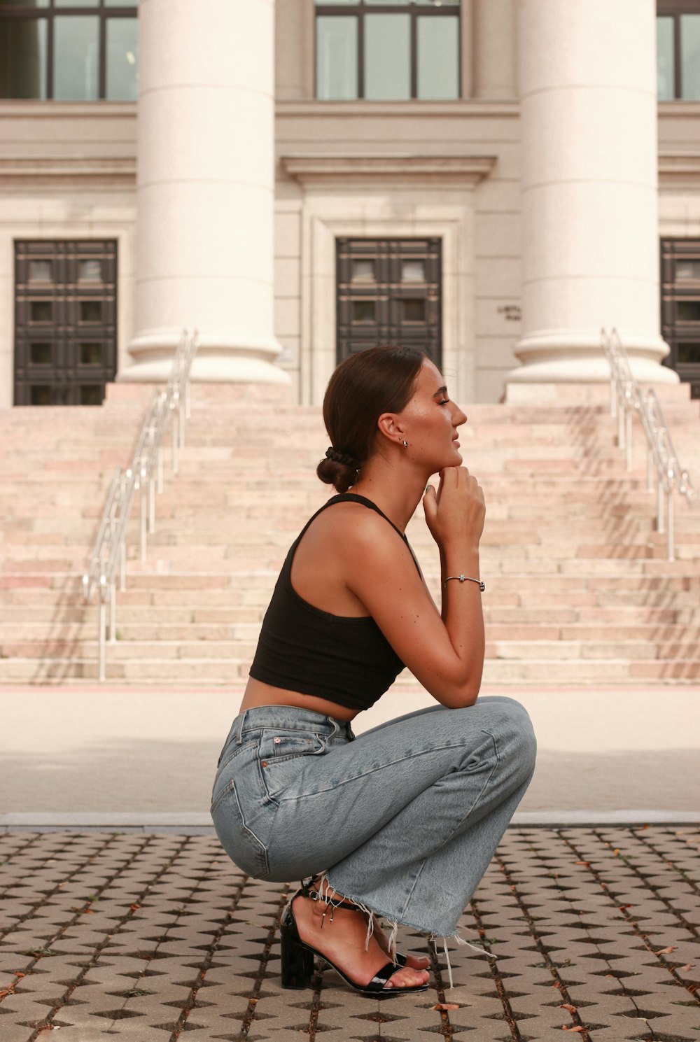 woman in black tank top and blue denim jeans sitting on floor