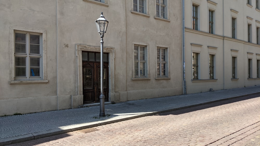 black street light near beige concrete building during daytime