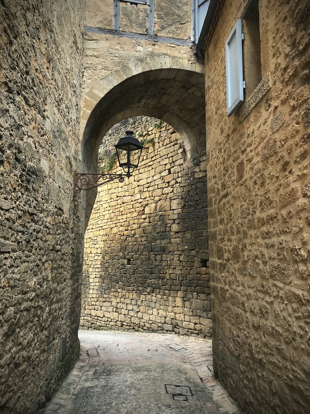 braune Ziegelmauer mit bogenförmigem Fenster