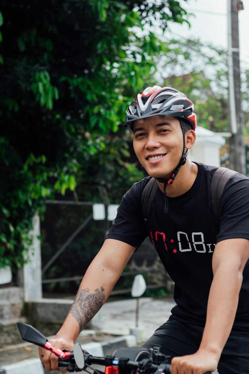 man in black crew neck t-shirt wearing black and white bicycle helmet