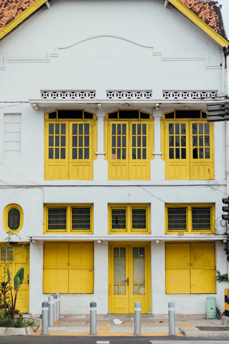 Casa real com fachada amarela e detalhes brancos