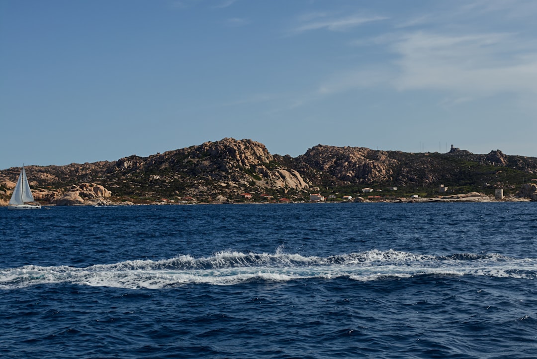 brown and green island on blue sea under blue sky during daytime