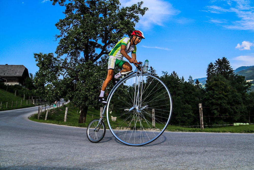 昼間、自転車に乗る緑のTシャツを着た男性