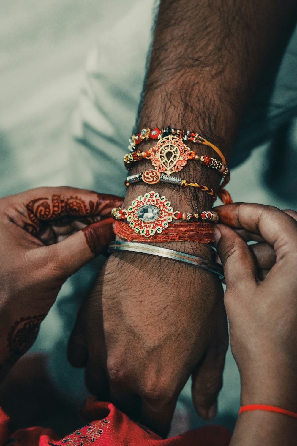 person wearing orange and black bracelets