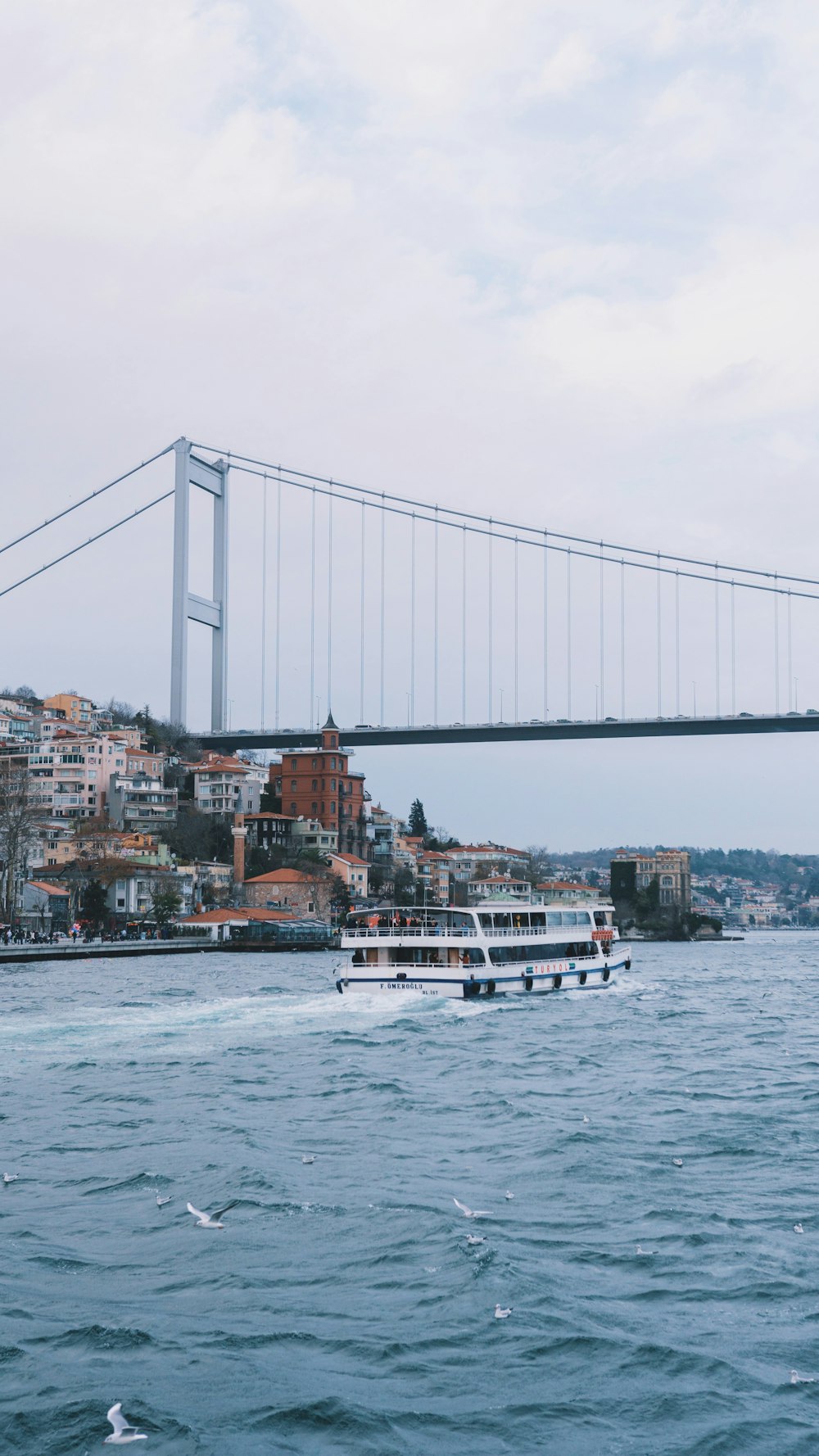 barco branco na água perto da ponte durante o dia