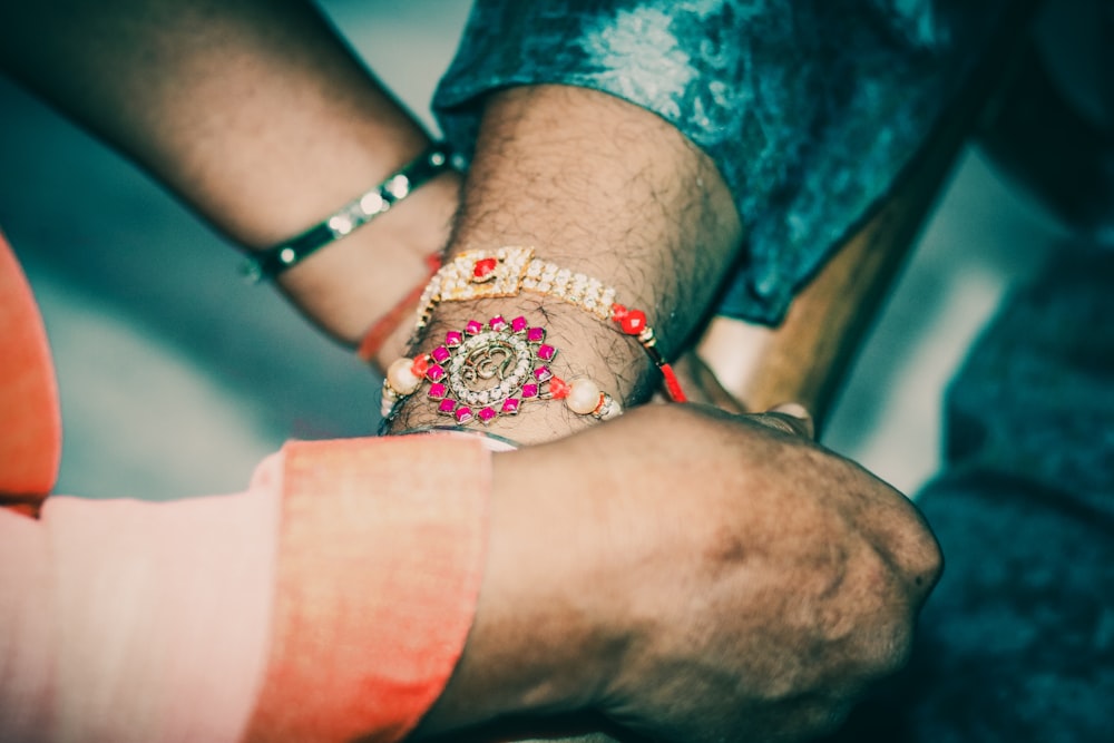 person wearing silver and red bracelet