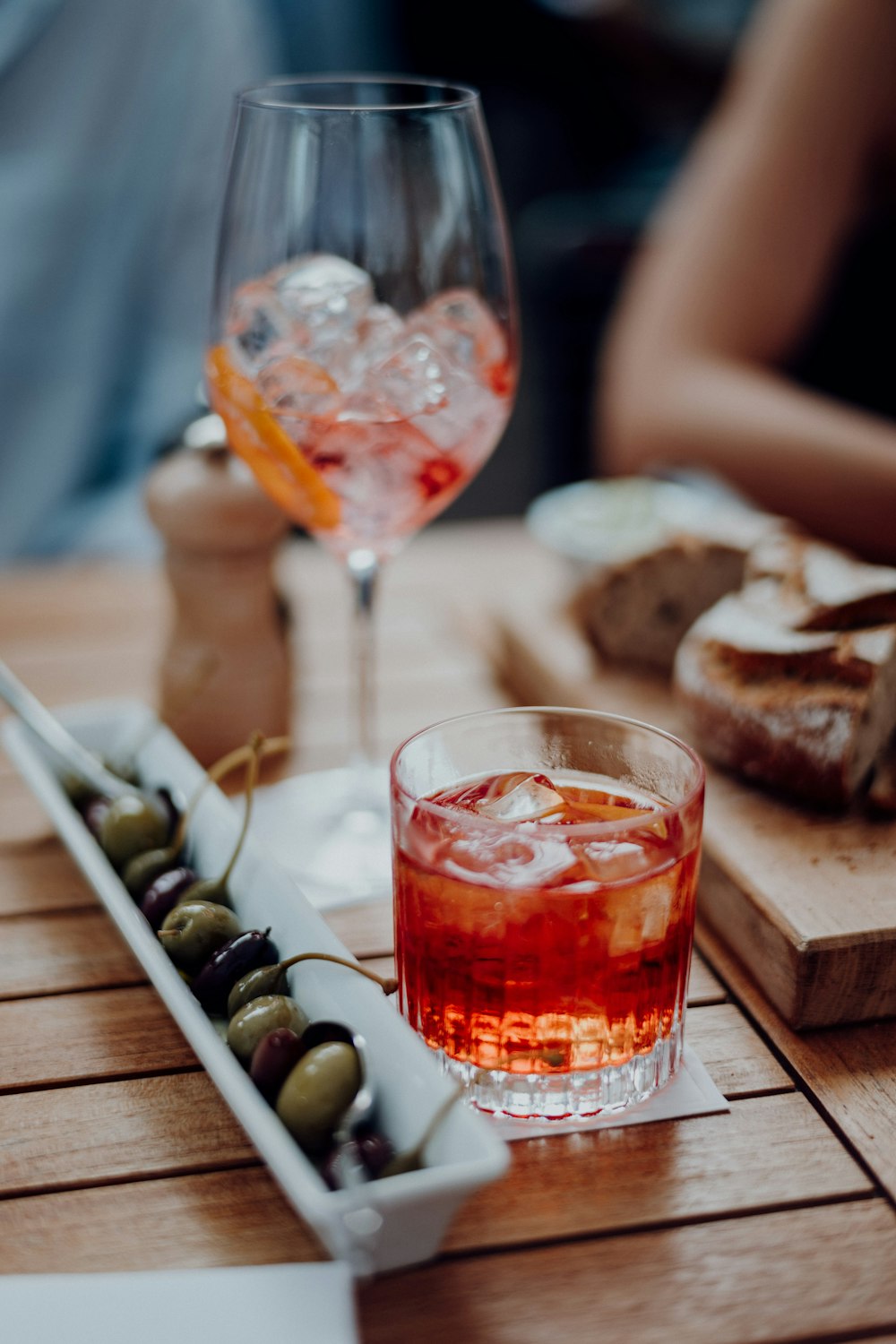 Vaso transparente con líquido rojo sobre mesa de madera marrón