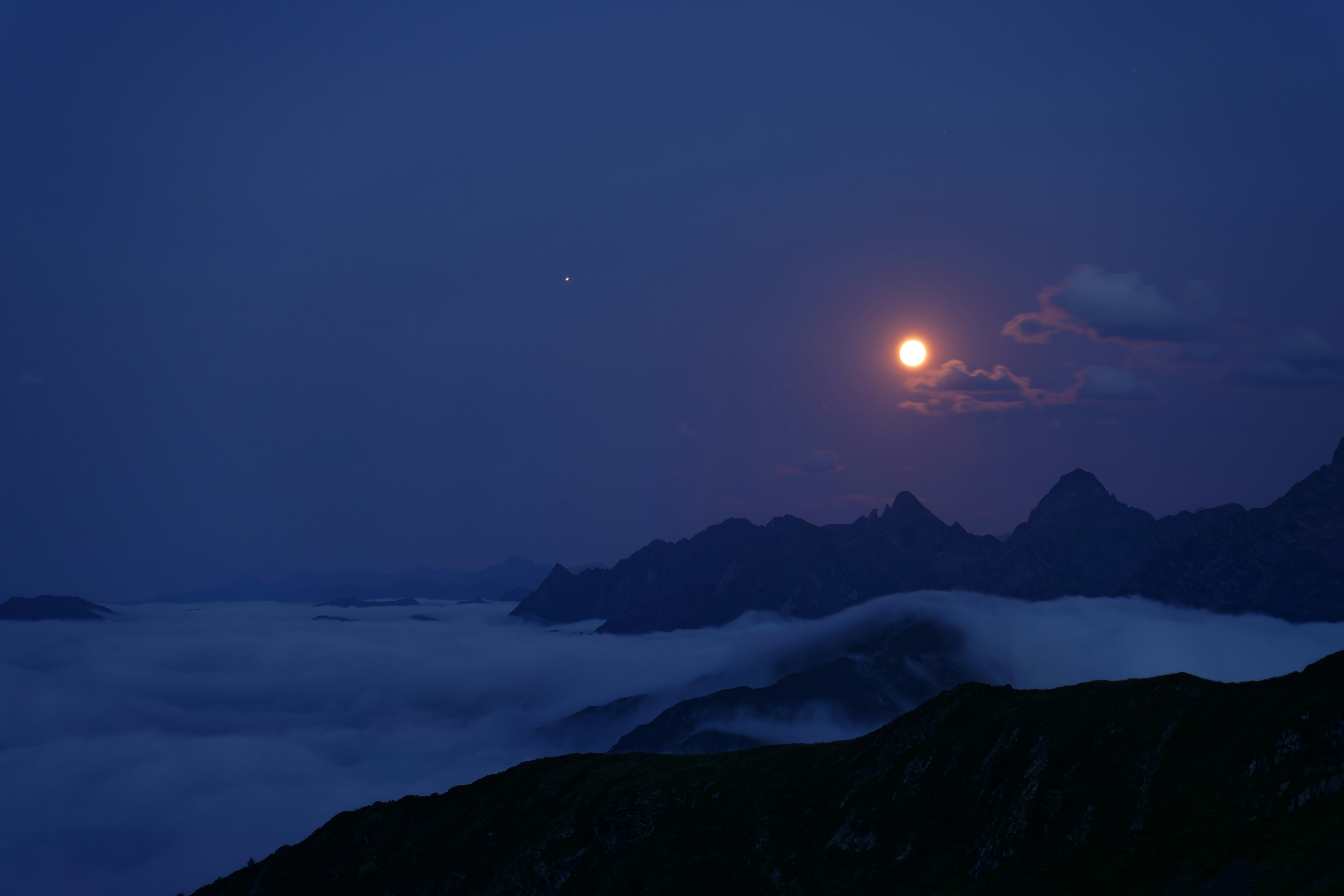 silhouette of mountains during night time