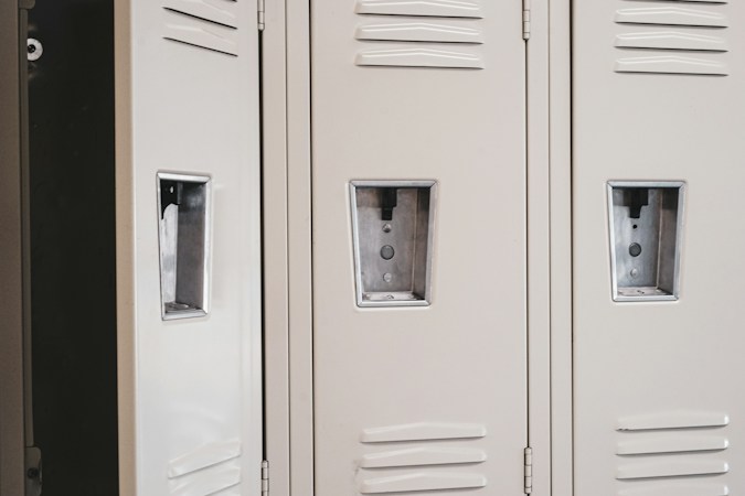 A single open locker in a school hallway, where random wand searches and staff check-ins help keep weapons off campus
