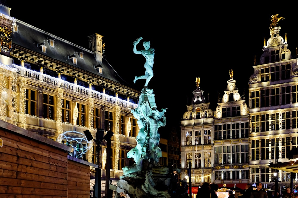 white concrete building with statue during night time