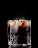 clear drinking glass with ice and black liquid