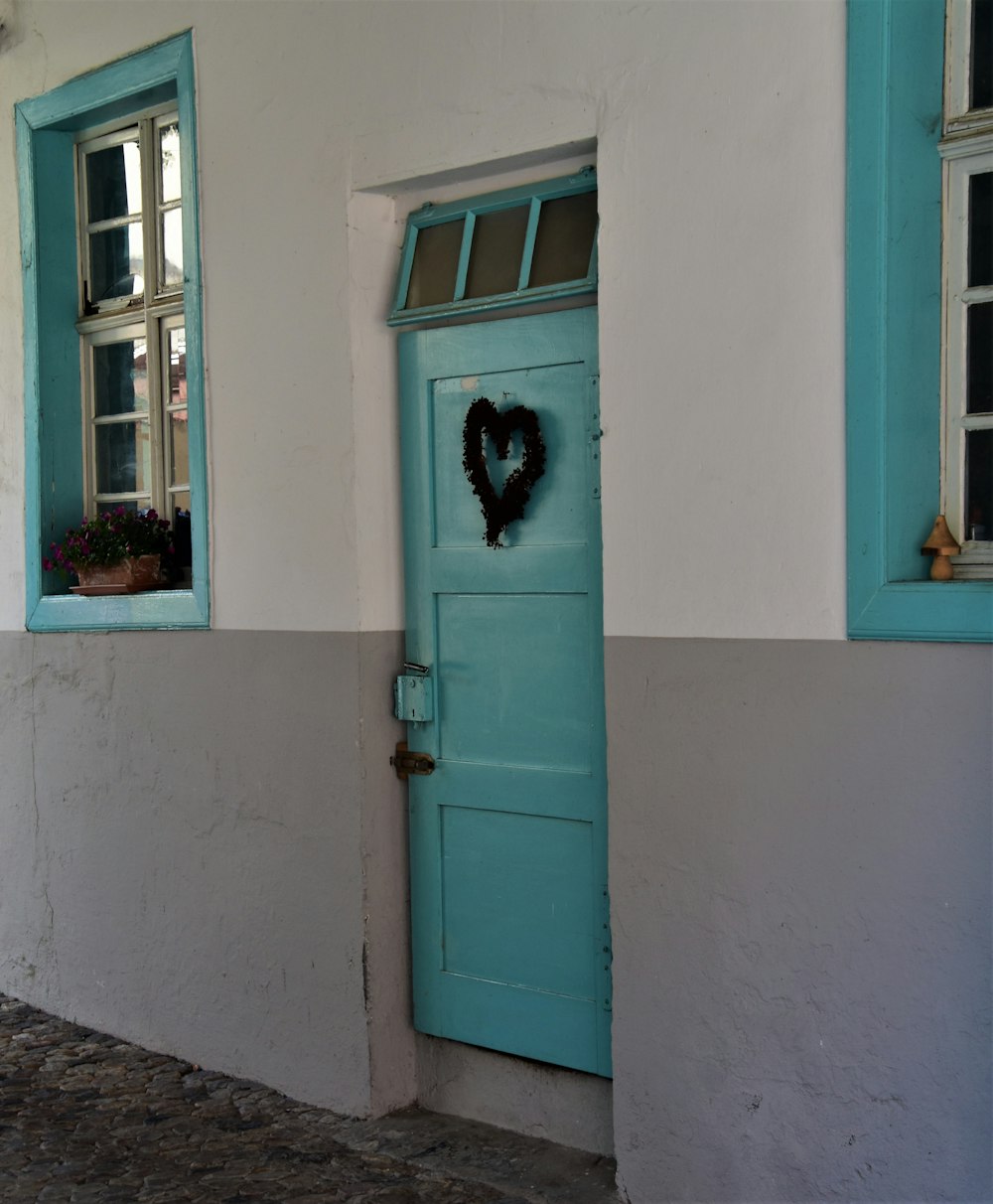 Puerta de madera azul con gato negro en la parte superior