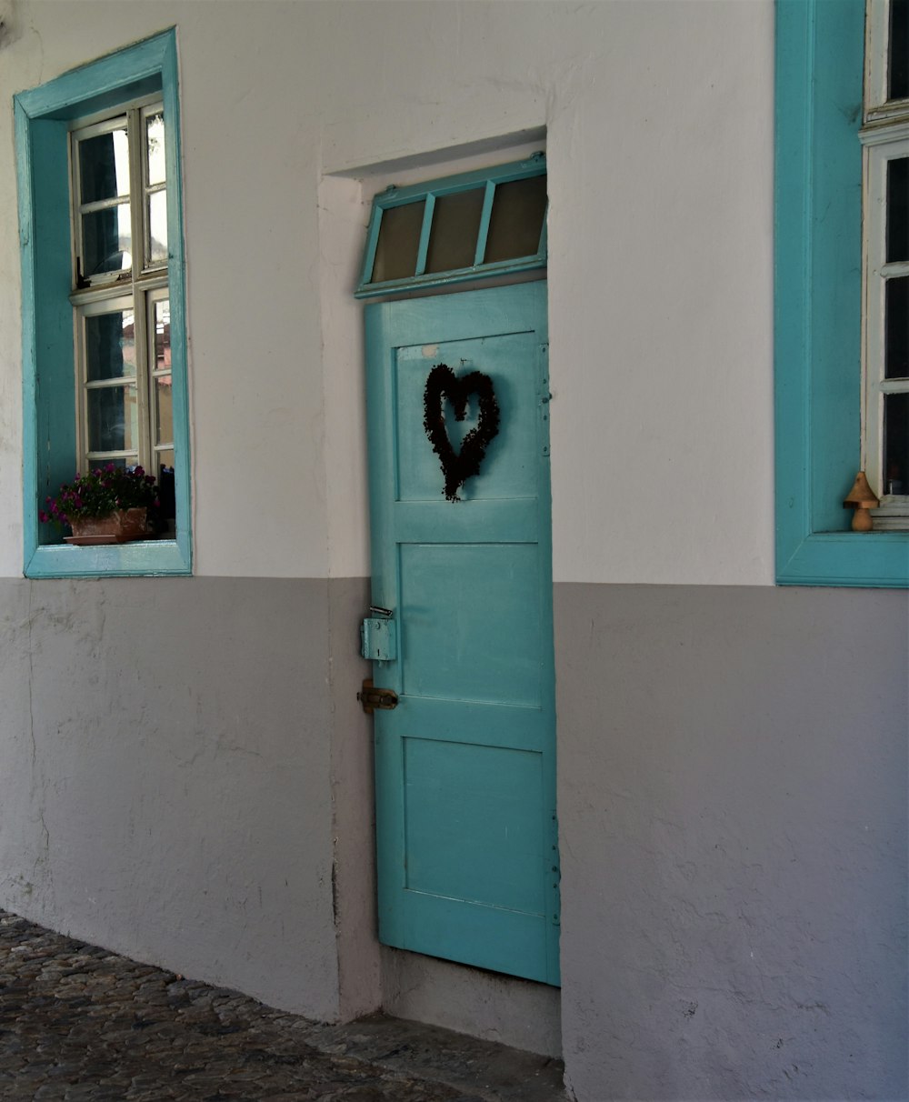 blue wooden door with black cat on top