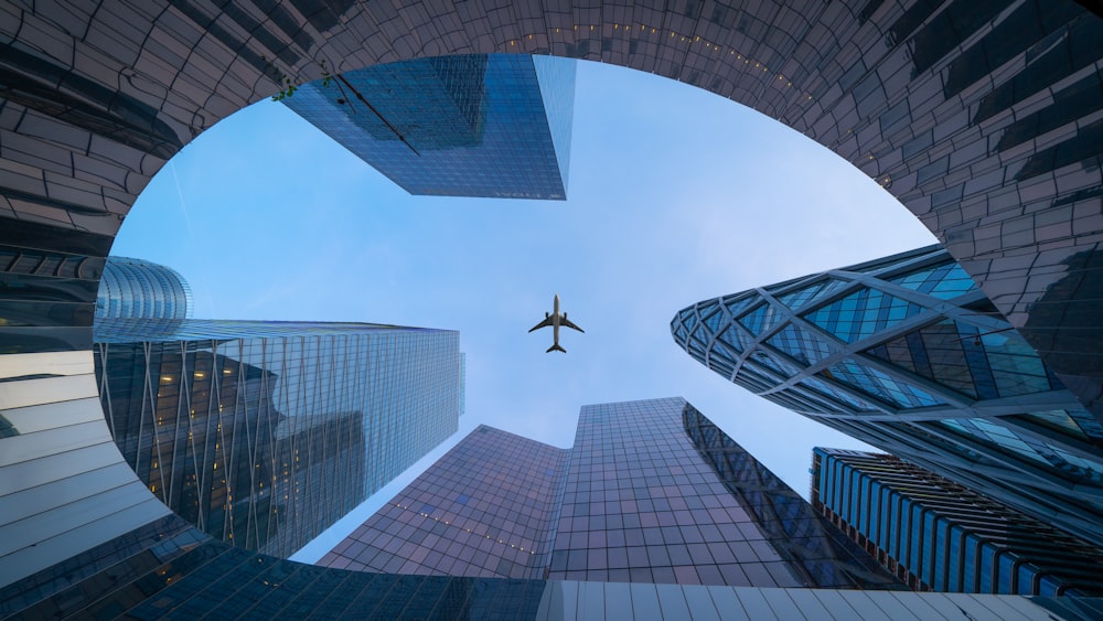 airplane flying over the building during daytime