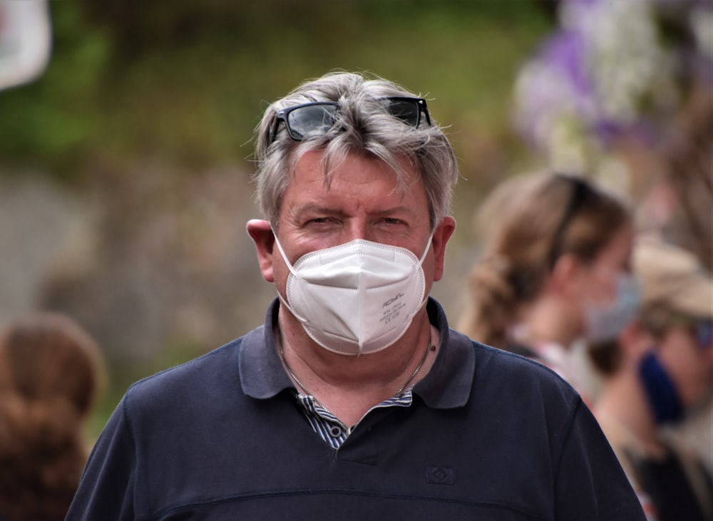 man in black polo shirt with white face mask