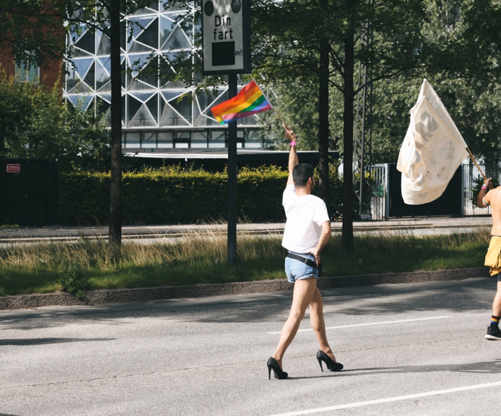 mulher na camisa branca e duques margaridas jeans azuis andando na estrada durante o dia