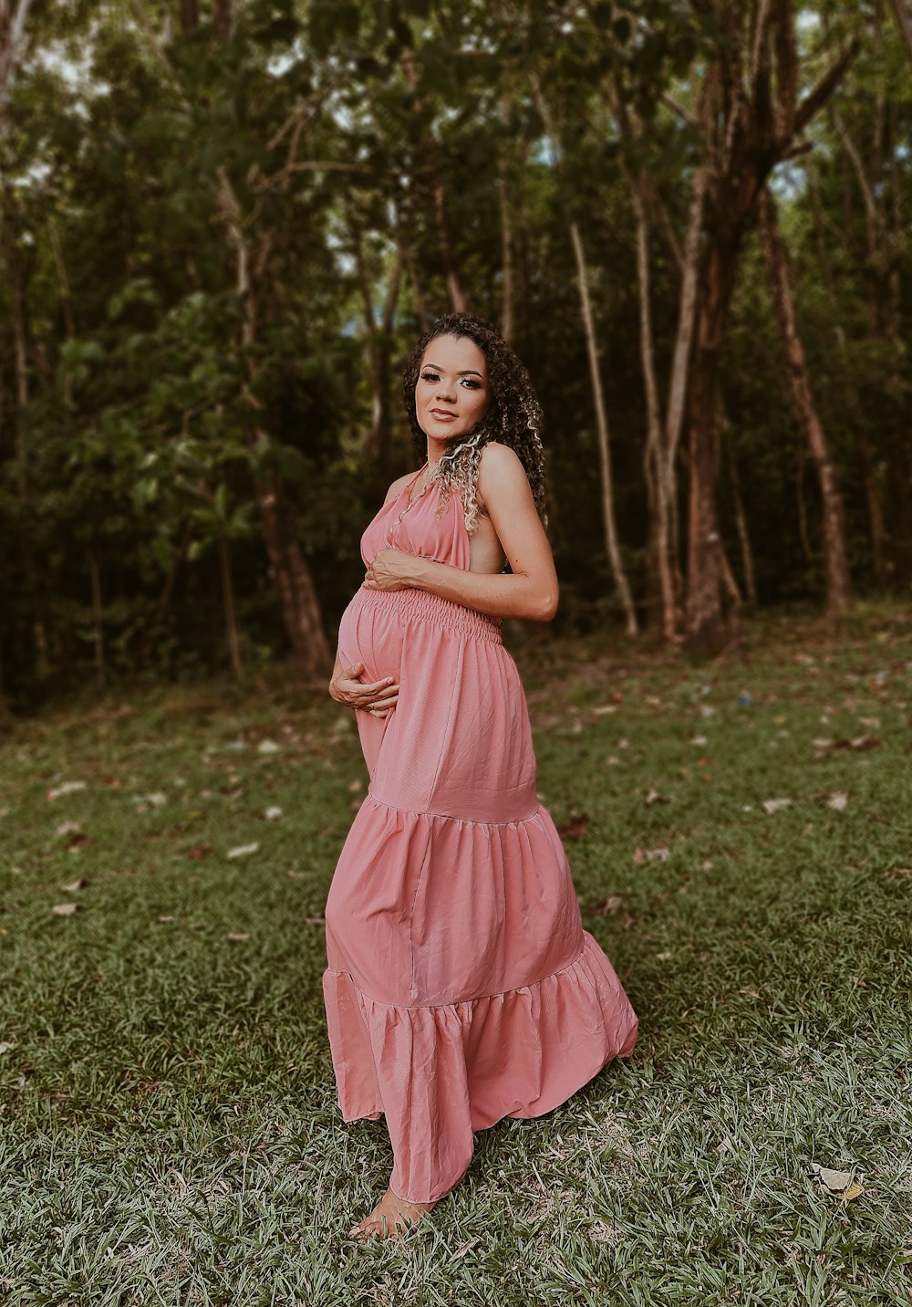 woman in pink dress standing on green grass field