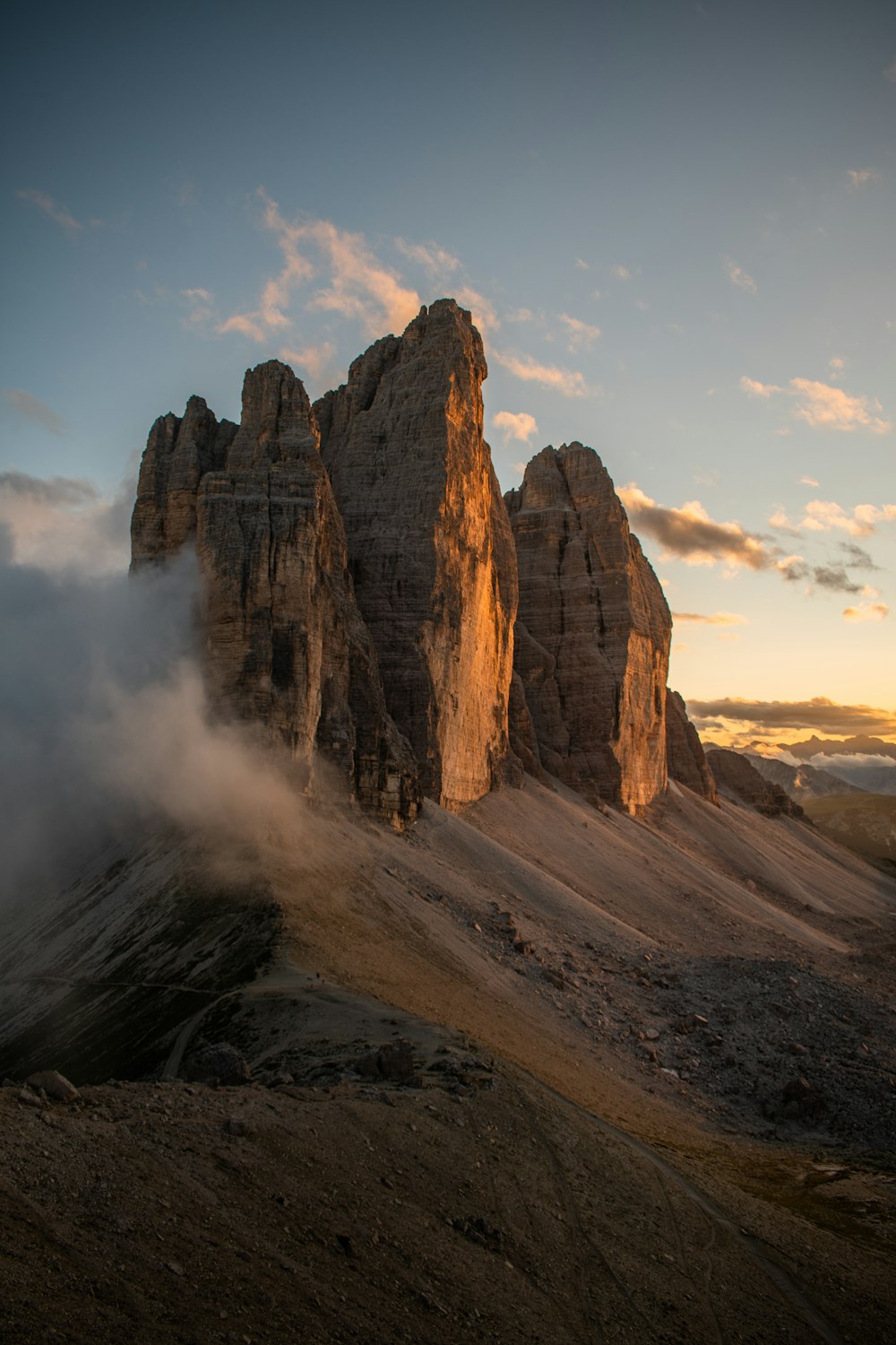 Montagne rocheuse brune sous des nuages blancs pendant la journée