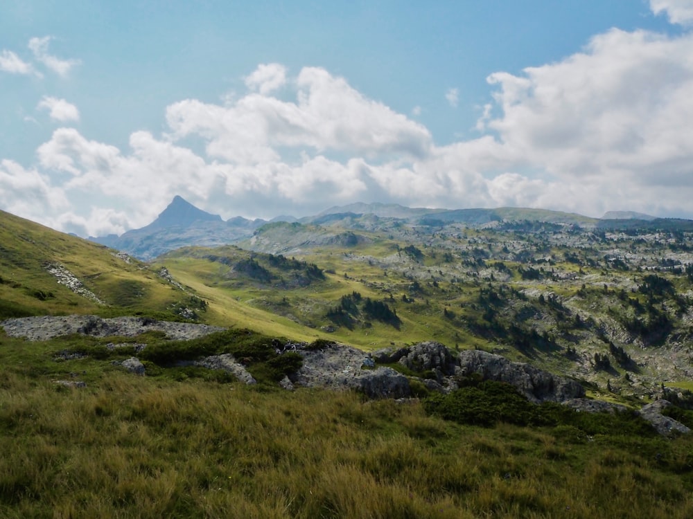 green and brown mountains under white clouds and blue sky during daytime