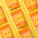 Several vibrant orange snack packages with the label 'LOVE CORN' are arranged diagonally on a bright yellow background. Each package is labeled as 'vegan cheesy flavored' and features corn kernels scattered around them.