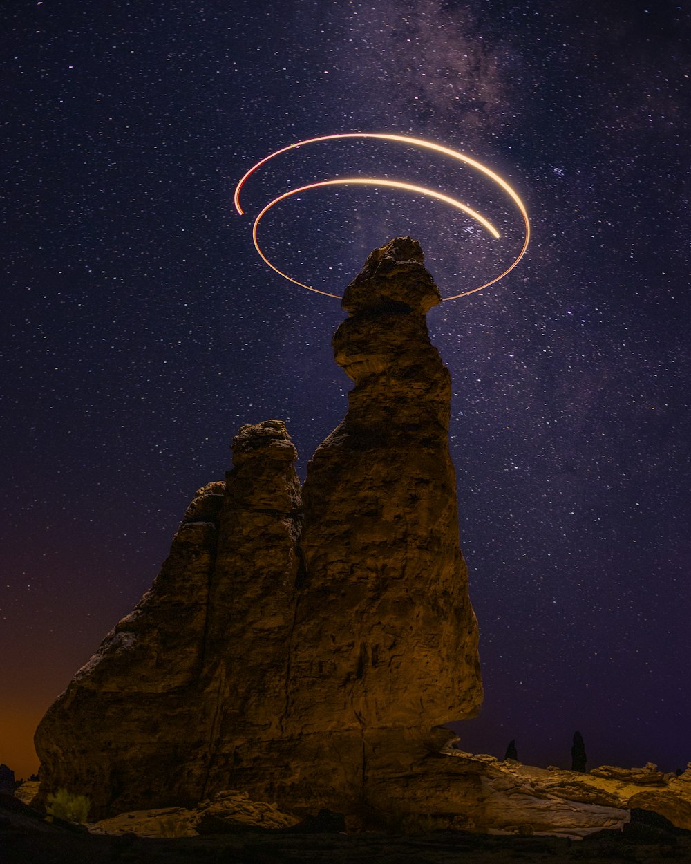 brown rock formation under starry night