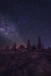 brown rock formation under starry night