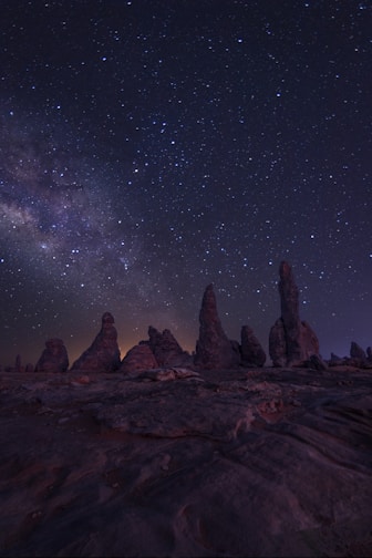 brown rock formation under starry night