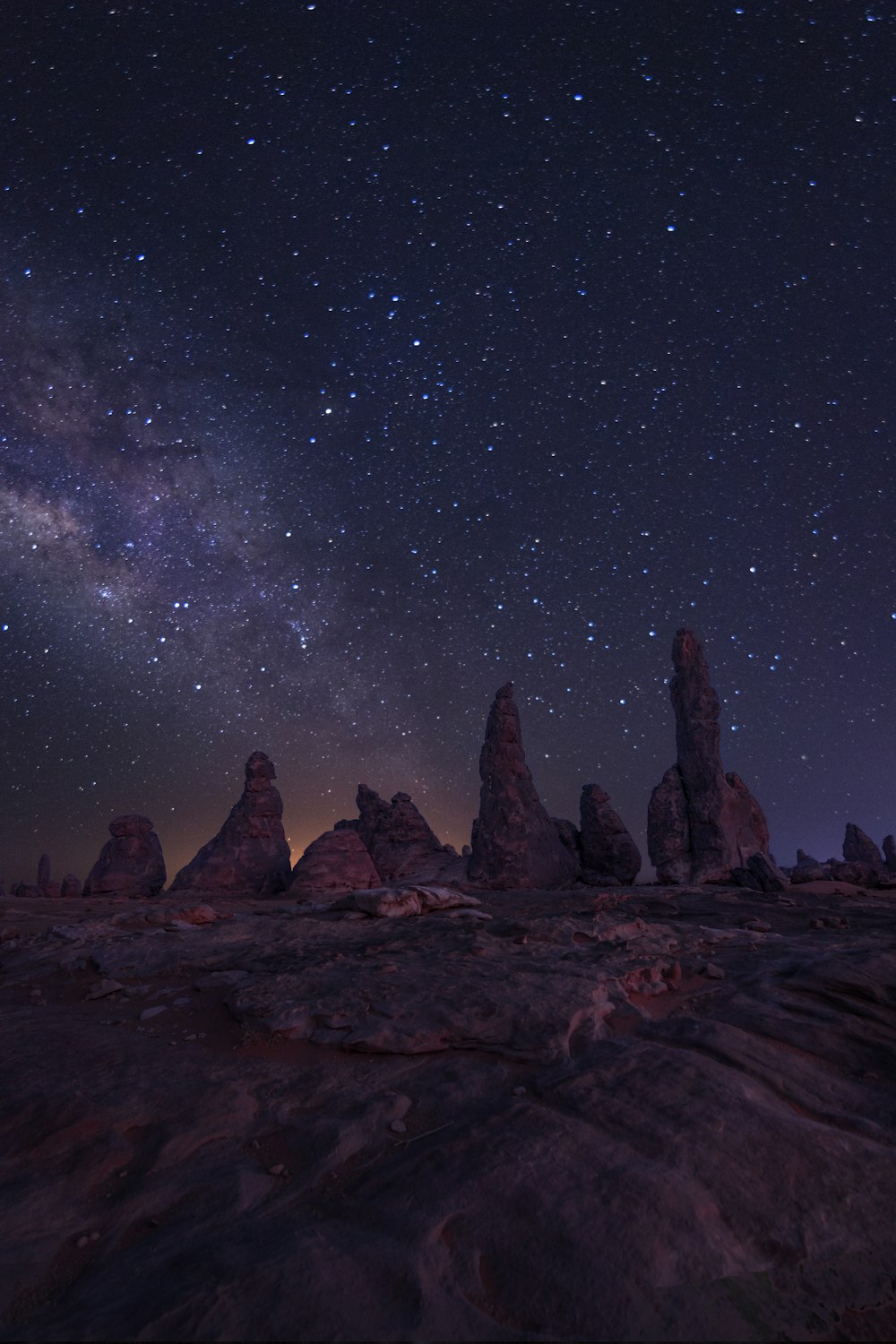 brown rock formation under starry night