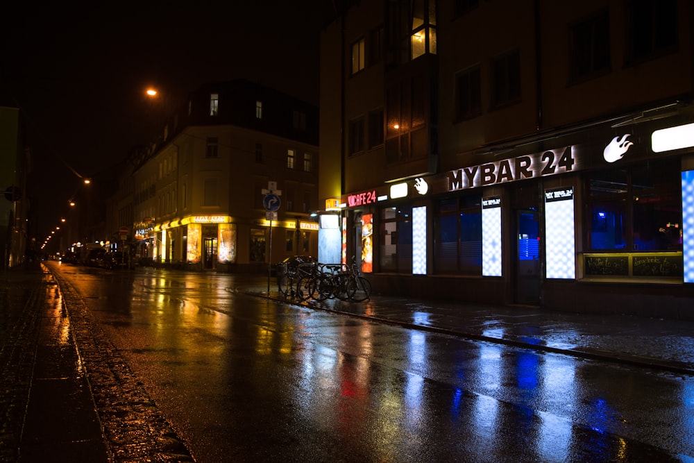 people walking on sidewalk near brown building during night time