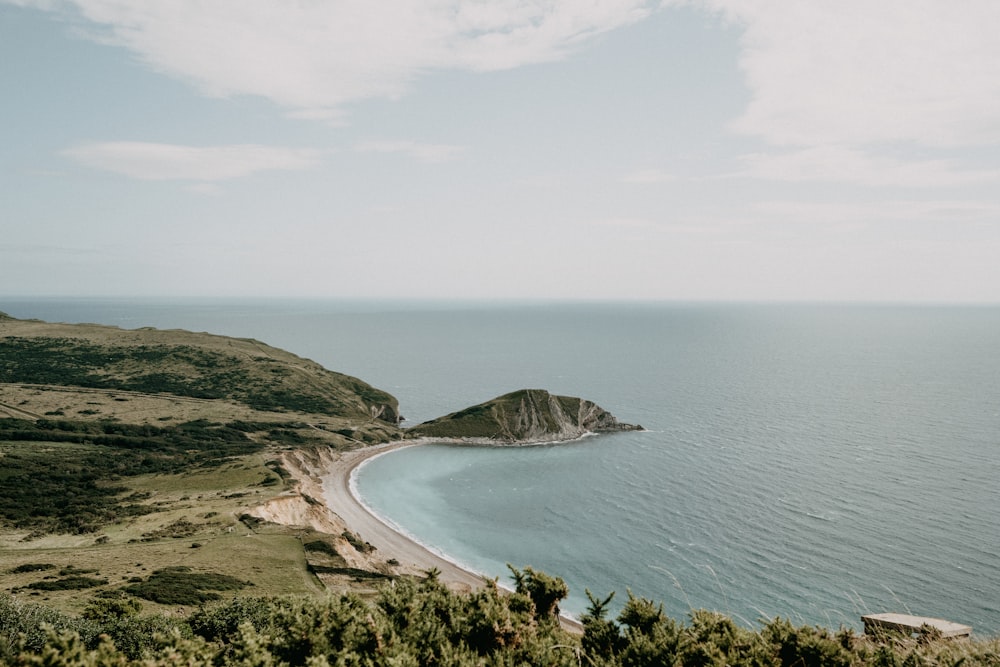 green mountain beside body of water during daytime