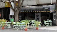 An outdoor seating area of Karavella Cafe with greenery.