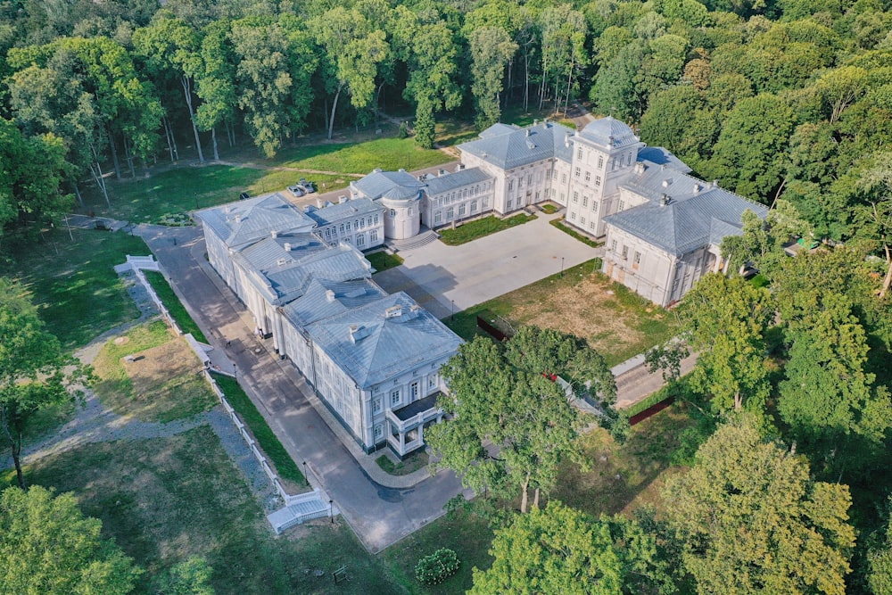 Veduta aerea dell'edificio in cemento bianco circondato da alberi verdi durante il giorno