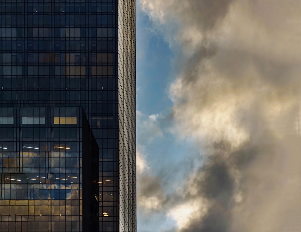 낮에는 흰 구름과 푸른 하늘 아래 회색 콘크리트 건물