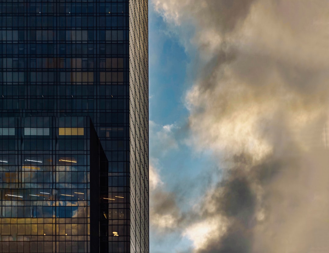 gray concrete building under white clouds and blue sky during daytime