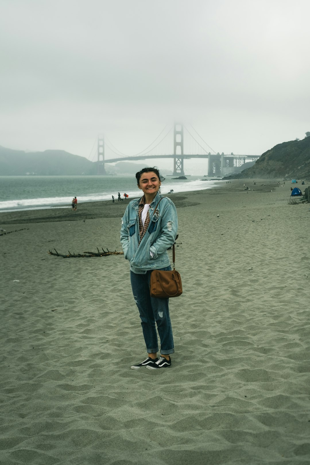 woman in blue denim jacket standing on beach during daytime