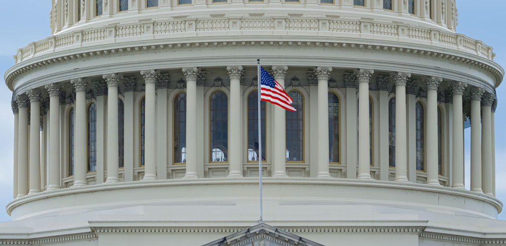 白いコンクリートの建物に国旗を掲げる米国