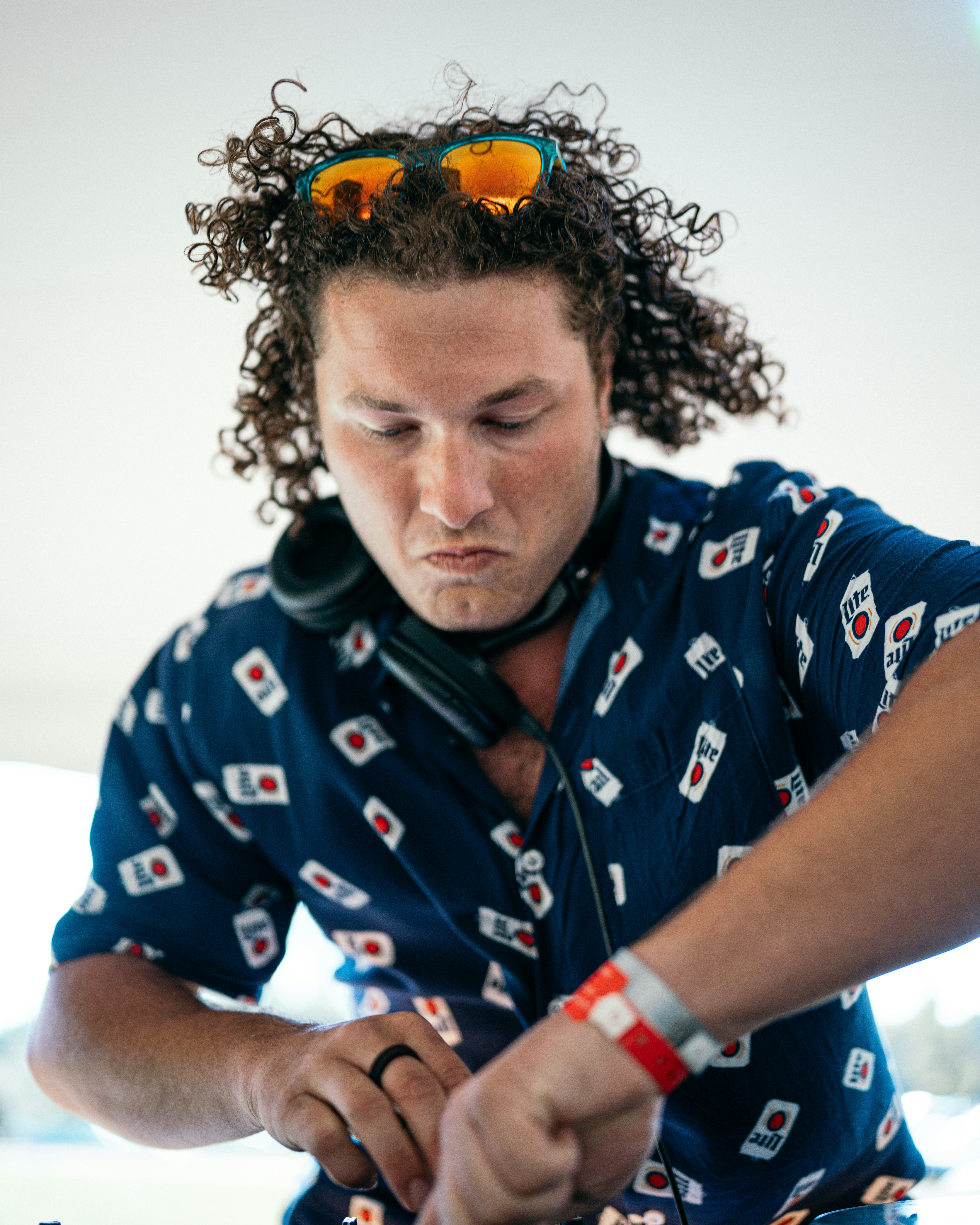 man in blue and white floral button up shirt with yellow and black hair tie