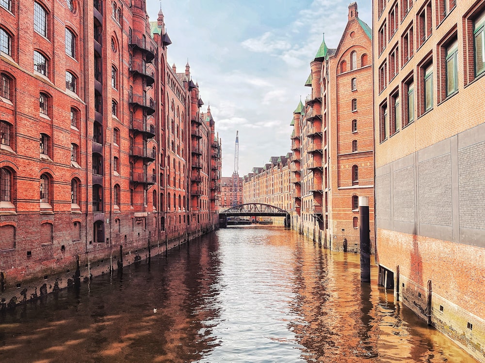 brown concrete building beside river during daytime