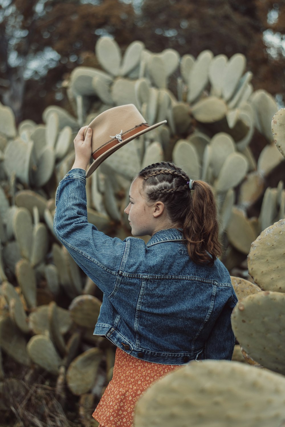 woman in blue denim jacket holding brown leather bag