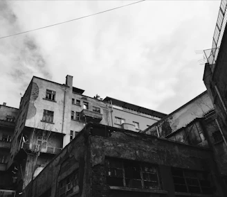 An artistic black and white photo of an old building’s textured wall with peeling paint.