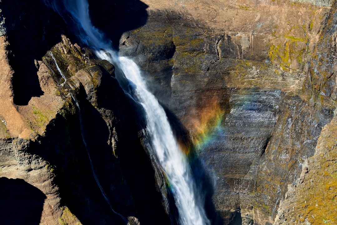 water falls on brown rocky mountain